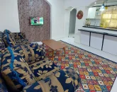 اتاق پذیرایی با مبلمان گلی آبی و آشپزخانه خانه ویلایی در قشم 565446
