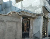 درب مشکی رنگ کوچک و نمای ساختمان سیمانی آپارتمان در قشم 48557464