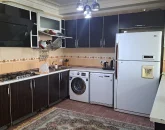 آشپزخانه با کابینت های مشکی، یخچال، لباسشویی آپارتمان در قشم 125346